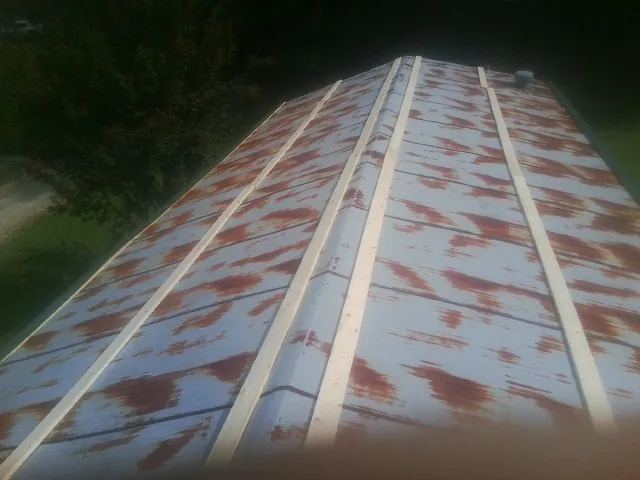 Rusted metal roof panels with new wood purlins before replacement — Storm Damage Roof Repair in Montrose by Roofing Brothers